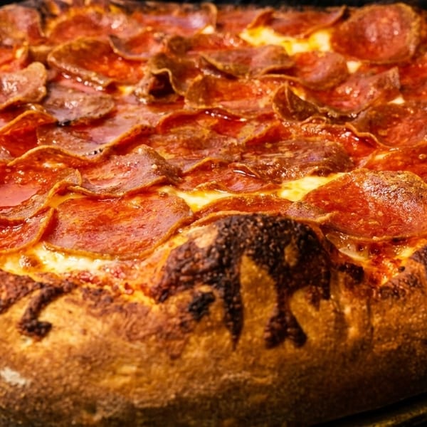 Close-up of a freshly baked pepperoni pizza with a thick, golden-brown crust.